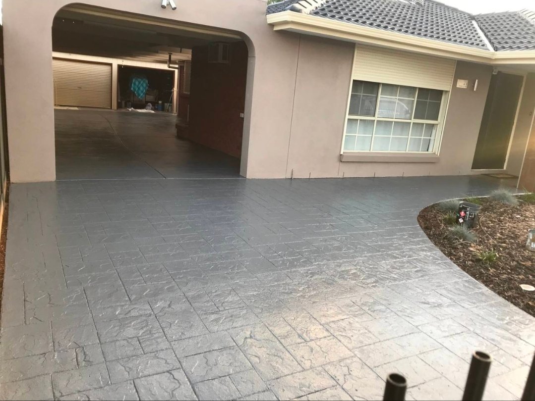 After driveway refresh photo showing the same driveway with a darker grey refreshed finish