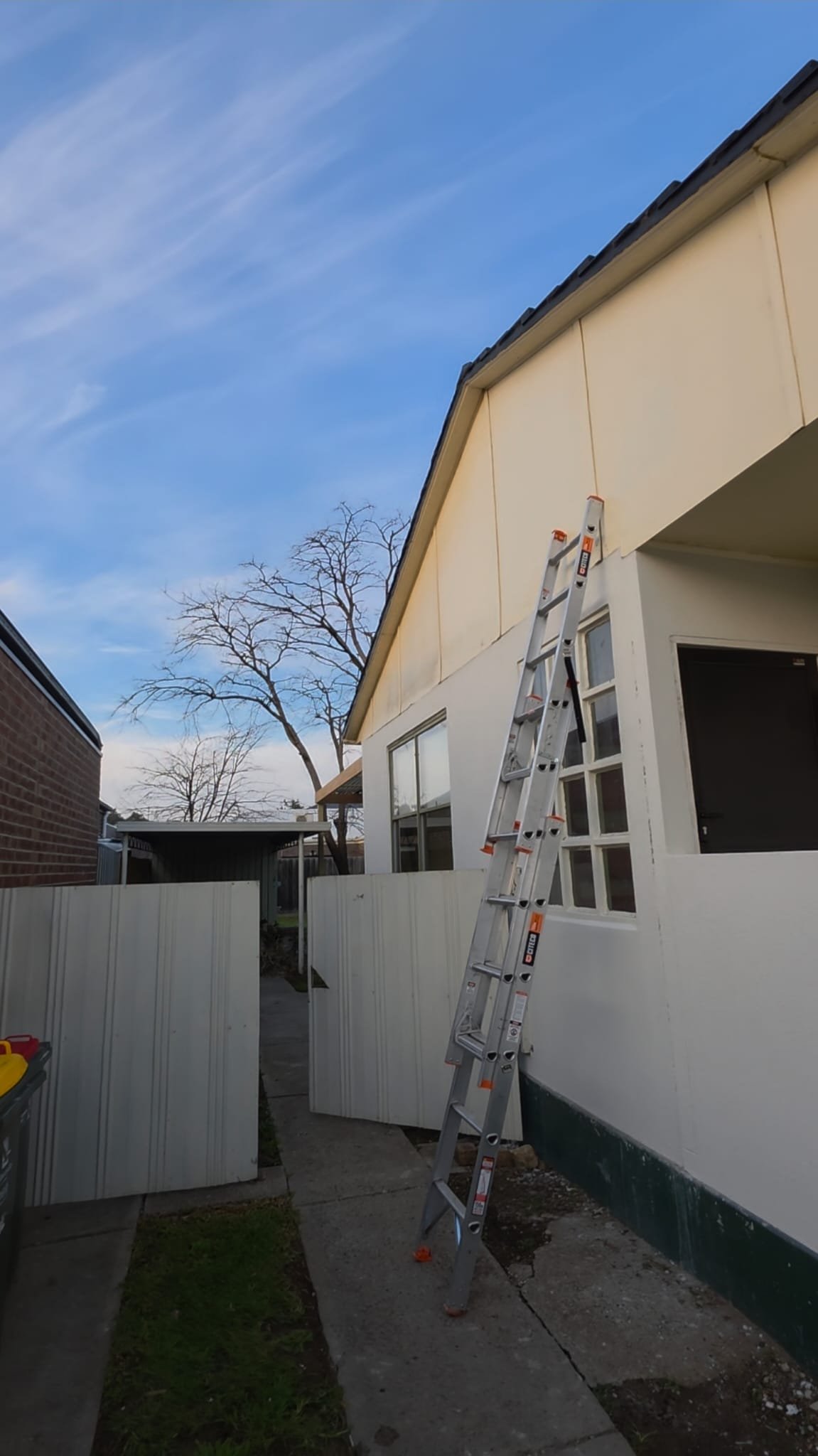 Before exterior refresh photo showing a cream side elevation before repainting