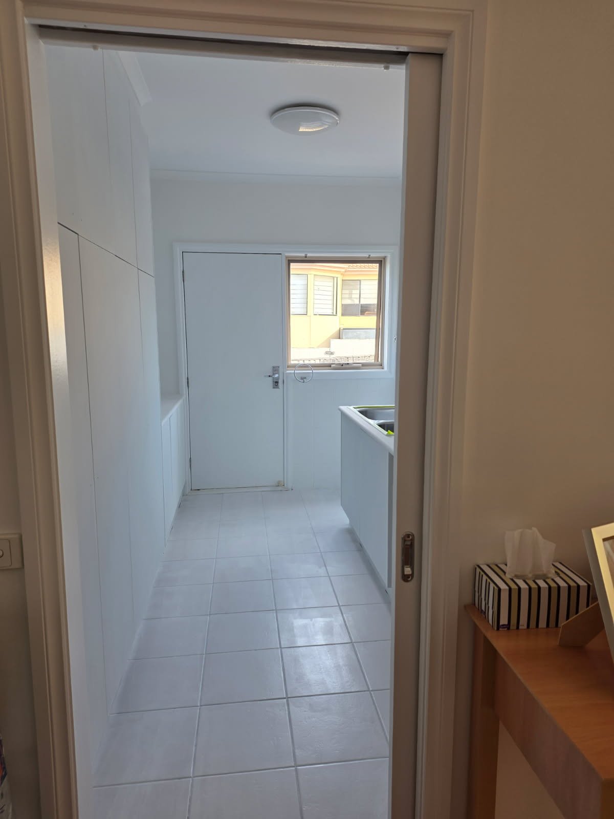 After laundry refresh photo showing the same laundry repainted in crisp white for a brighter cleaner finish