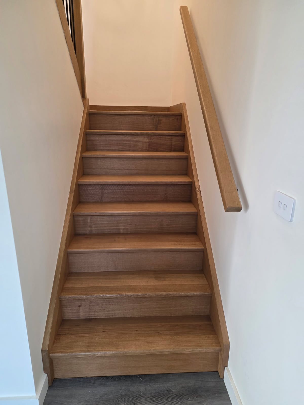 After staircase timber finish photo showing the same stairs with a richer warmer timber finish